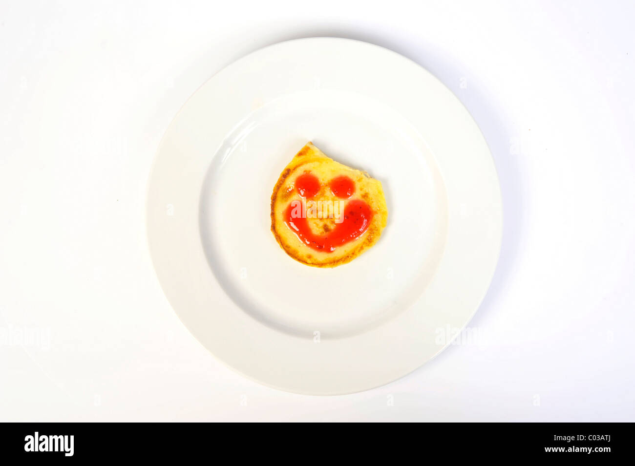 Quark-Pfannkuchen mit einem Gesicht gezeichnet mit marmelade Stockfoto