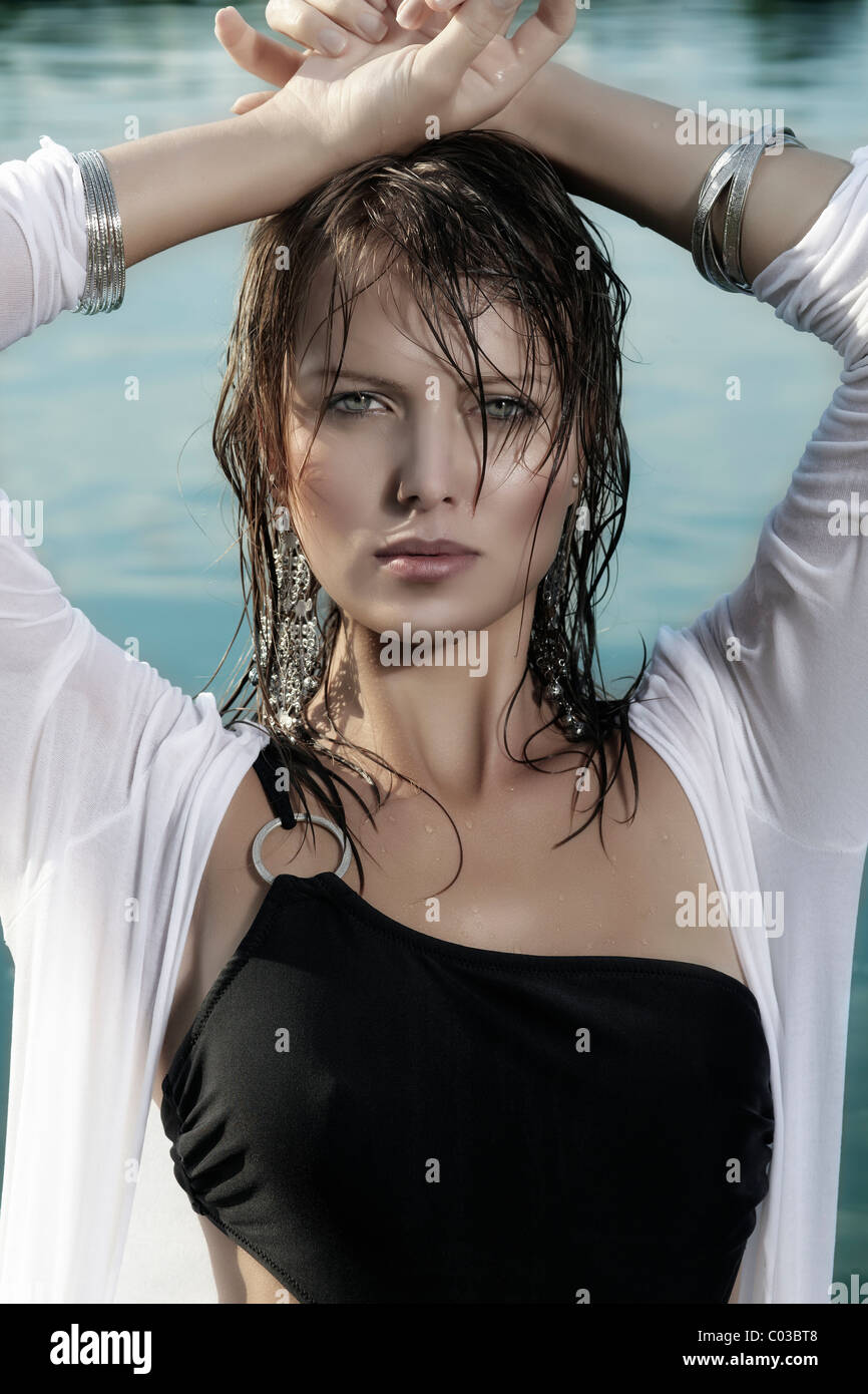 Junge Frau in einem schwarzen Badeanzug, ein weißes Top und mit nassen Haaren, Baden in einem See Stockfoto