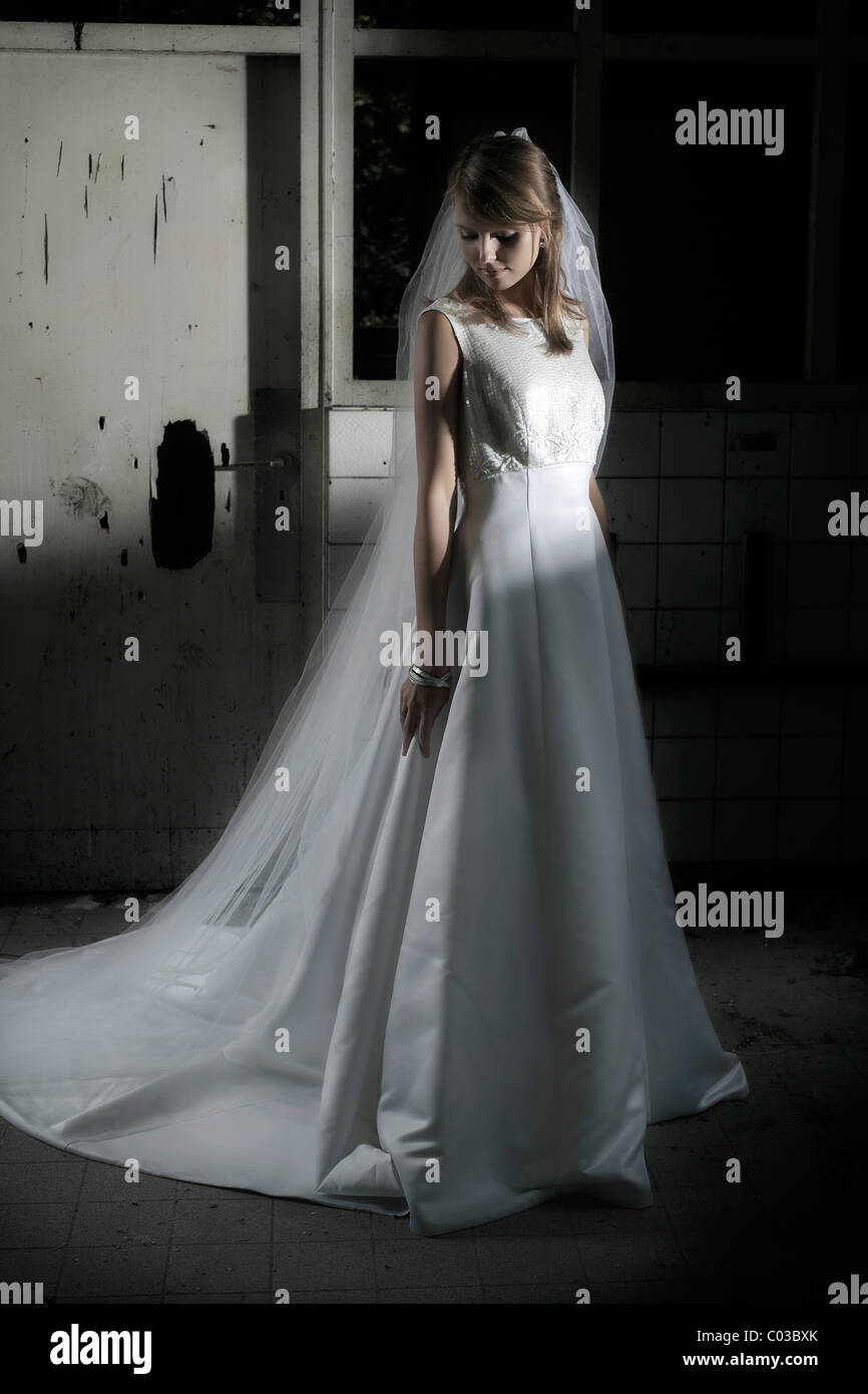 Junge Frau im Brautkleid mit Schleier in innerstädtischer Lage Stockfoto