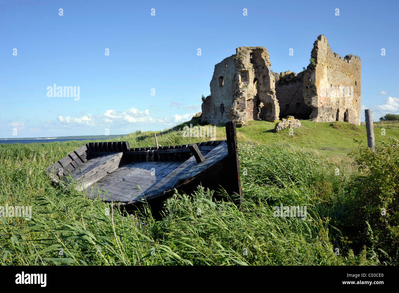 Boot am Ostsee-Strand vor den Ruinen der Burg des Deutschen Ordens, Toolse, Estland Stockfoto