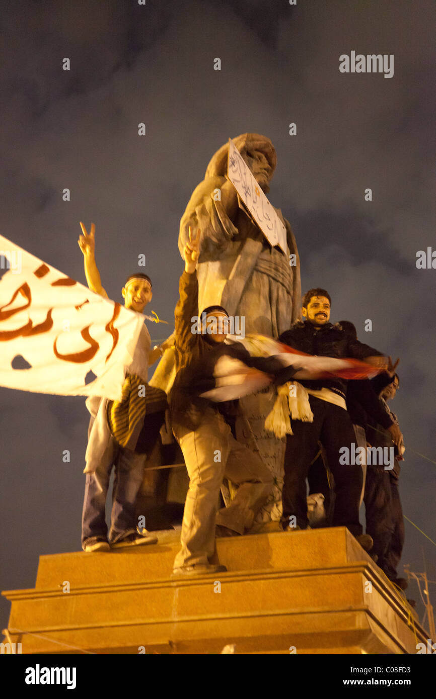 Ägyptischen Demonstranten feiert Sieg in der Revolution auf dem Tahrir auf Statue von Omar Makram Stockfoto