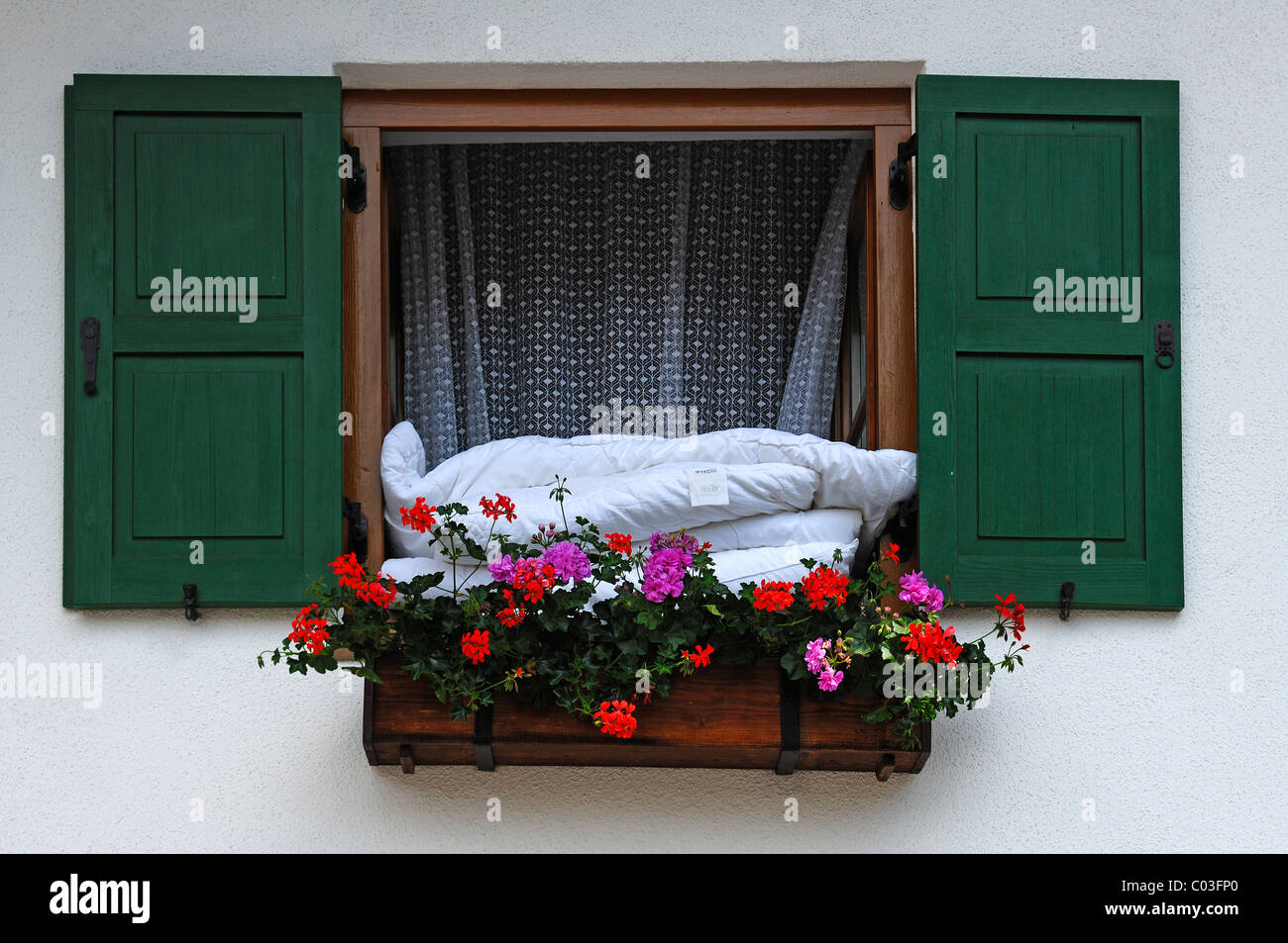 Bettdecken aus einem Fenster mit Blumenkasten für Lüftung, Mittenwald,  Upper Bavaria, Bavaria, Germany, Europa hängen Stockfotografie - Alamy