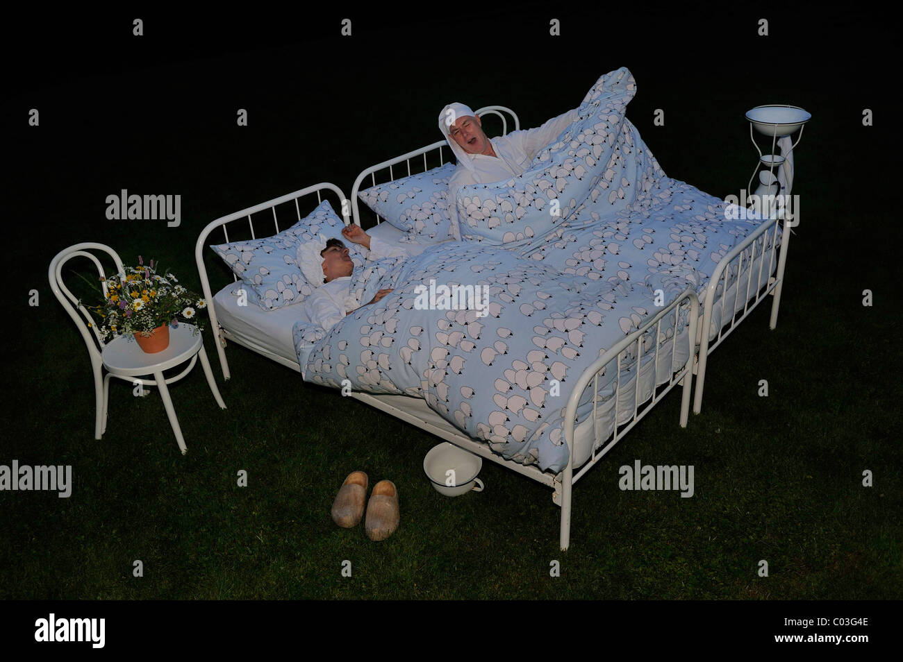 Schüler/inen mit Nachthemden, Nachtmützen und Nachttopf schlafen im Garten, verrückte Hotels, Pension Pension Kamerichs Stockfoto