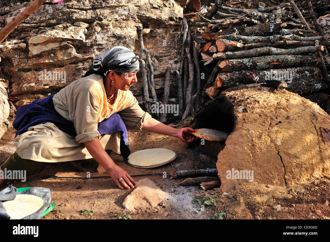 Ältere Frau Backen Pita-Brot in einem Lehmofen, mittleren Atlas, Marokko, Afrika Stockfoto