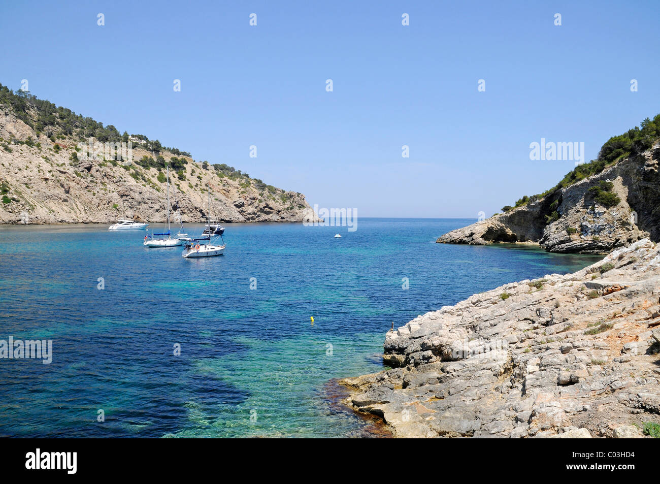 Boote in einer Bucht, Cala Llonga, Felsenküste, Santa Eulalia des Riu, Ibiza, Pityusen, Balearen, Spanien, Europa Stockfoto