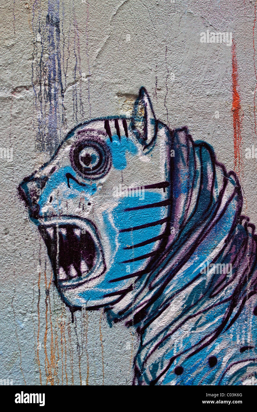 Graffiti, ein Fabelwesen mit einem klaffenden Mund und scharfen Zähnen an einer Wand Stockfoto