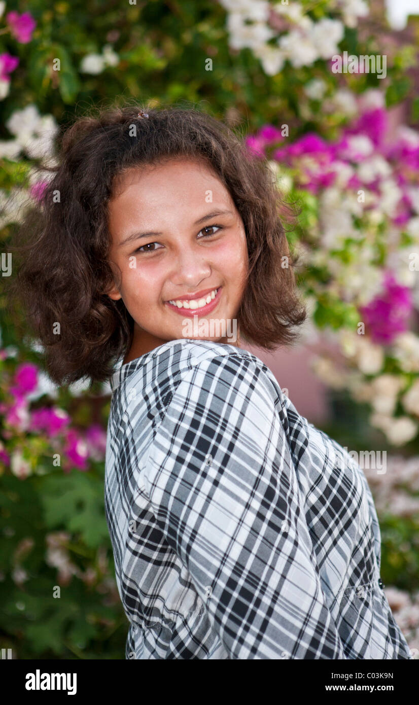 Porträt eines 13 Jahre alten Mädchens vor Blumen Stockfoto