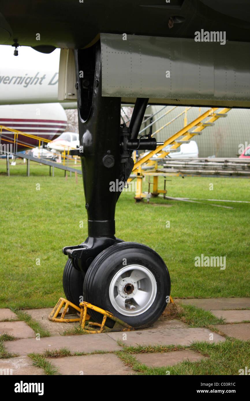 Ein Rad der Landung eines Flugzeugs mit Unterlegkeile. Das Flugzeug ist Briefpapier. Stockfoto