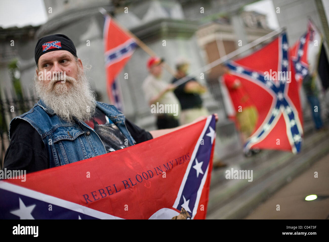 Flagge der Konföderierten Freistellungen Stand vor der Jefferson Davis-Statue in der Monument Avenue in Richmond, Virginia, USA. Stockfoto