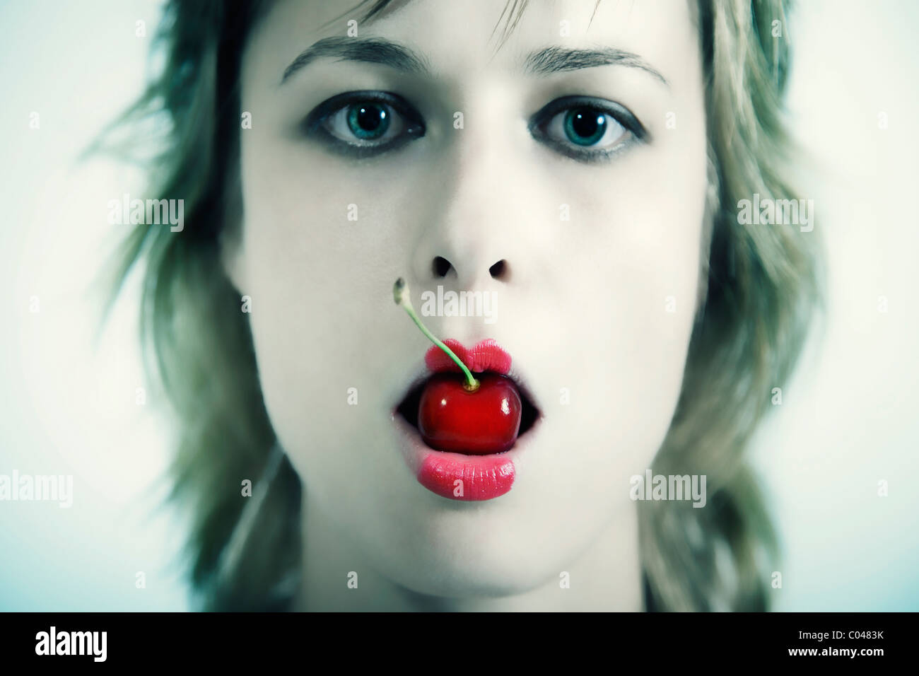 Gesicht der junge schöne Mädchen mit Kirsche in Mund Stockfoto