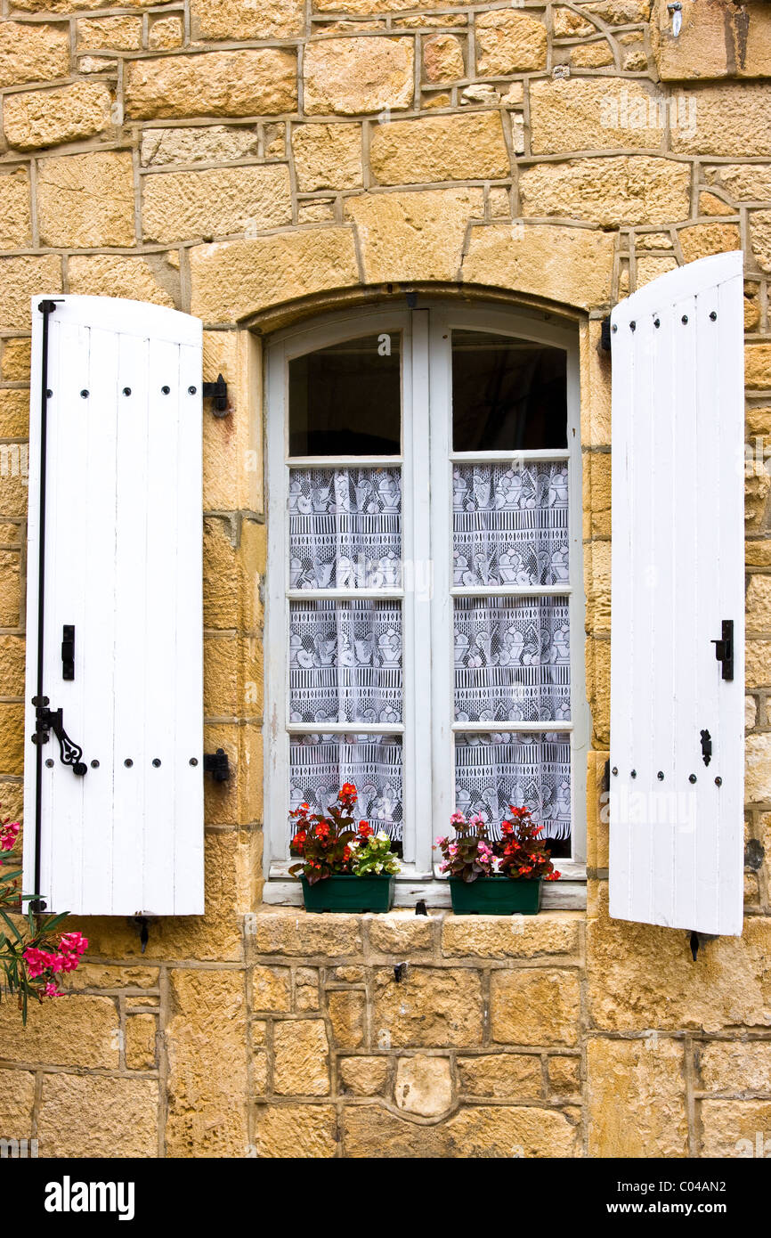 Traditionelle französische Fenster Gardinen Rollläden Balkonkästen in malerischen Sarlat, Dordogne, Frankreich Stockfoto