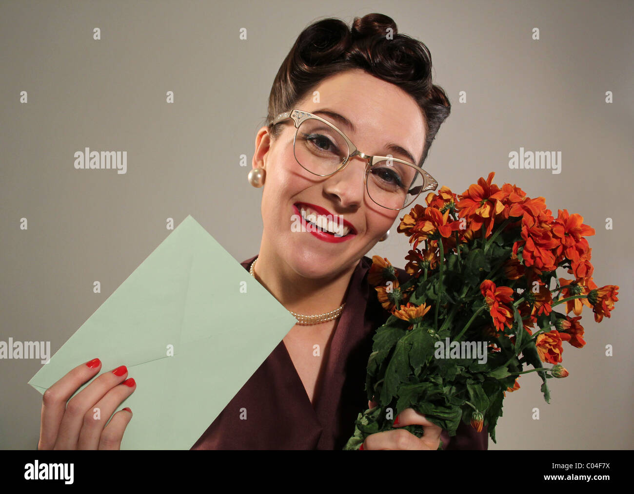 Retro-Frau mit einem Blumenstrauß und einer Karte, Bild von Tony Rusecki Stockfoto