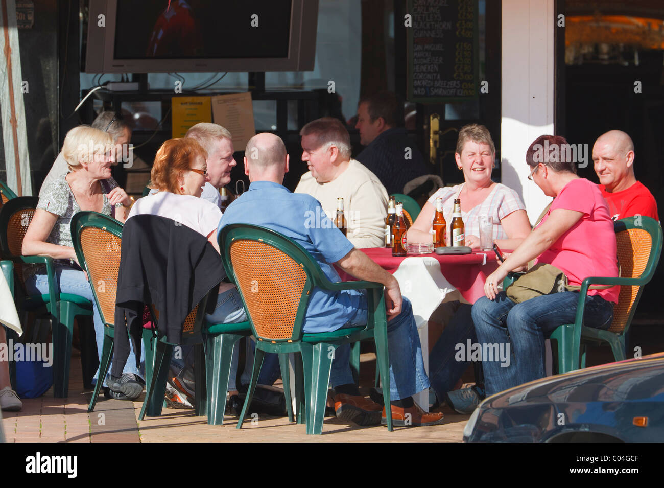 Touristen im Gespräch über eine Bar, Terrasse. Provinz Los Boliches, Fuengirola, Malaga, Costa Del Sol, Spanien. Stockfoto