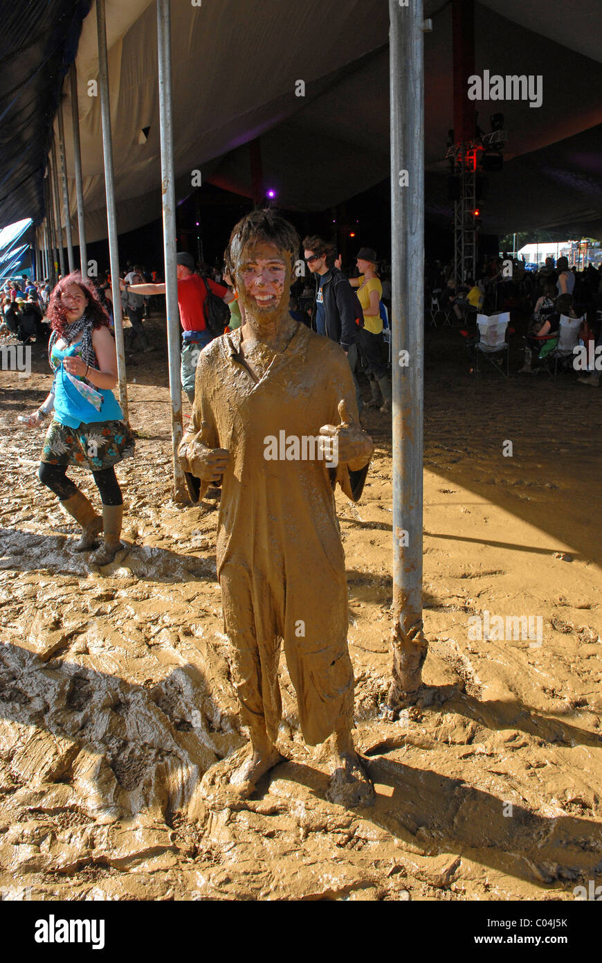 Junger Mann bedeckt im Schlamm an WOMAD Festival, Malmesbury, Wiltshire, Großbritannien Stockfoto