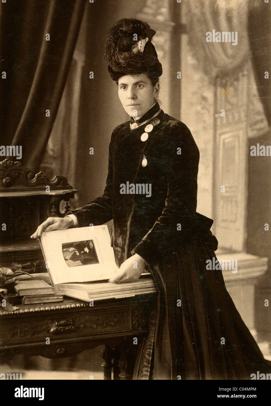 Viktorianische Frau auf der Suche durch ein Foto Album der Familie Fotos c1880. Vintage Schrank Karte Stockfoto