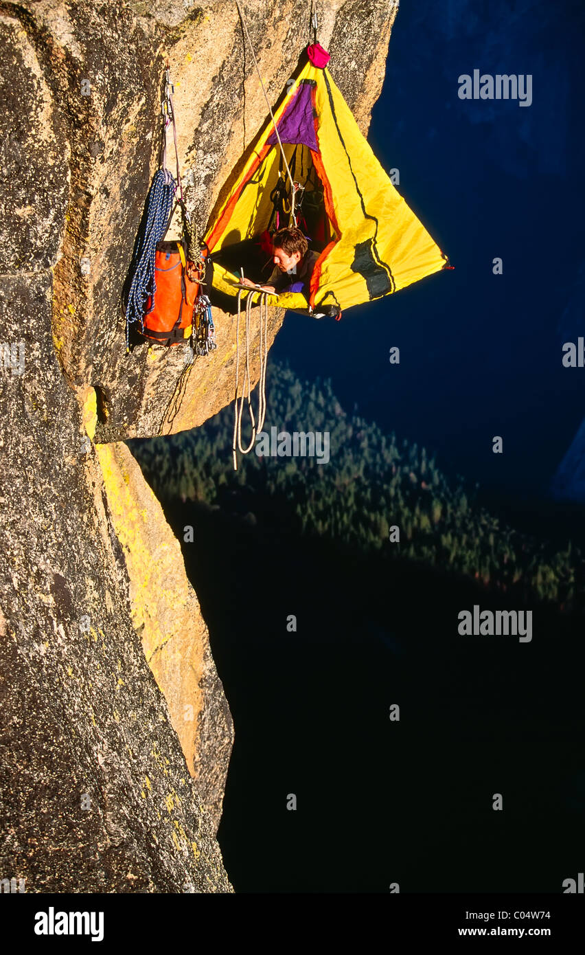 Kletterer biwakierten in seinem Portaledge auf einem überhängenden Felsen. Stockfoto