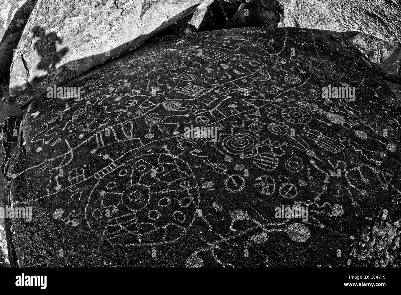 Einsamer Wanderer erforscht alte Petroglyphen in einem vulkanischen Felsen geätzt. Stockfoto
