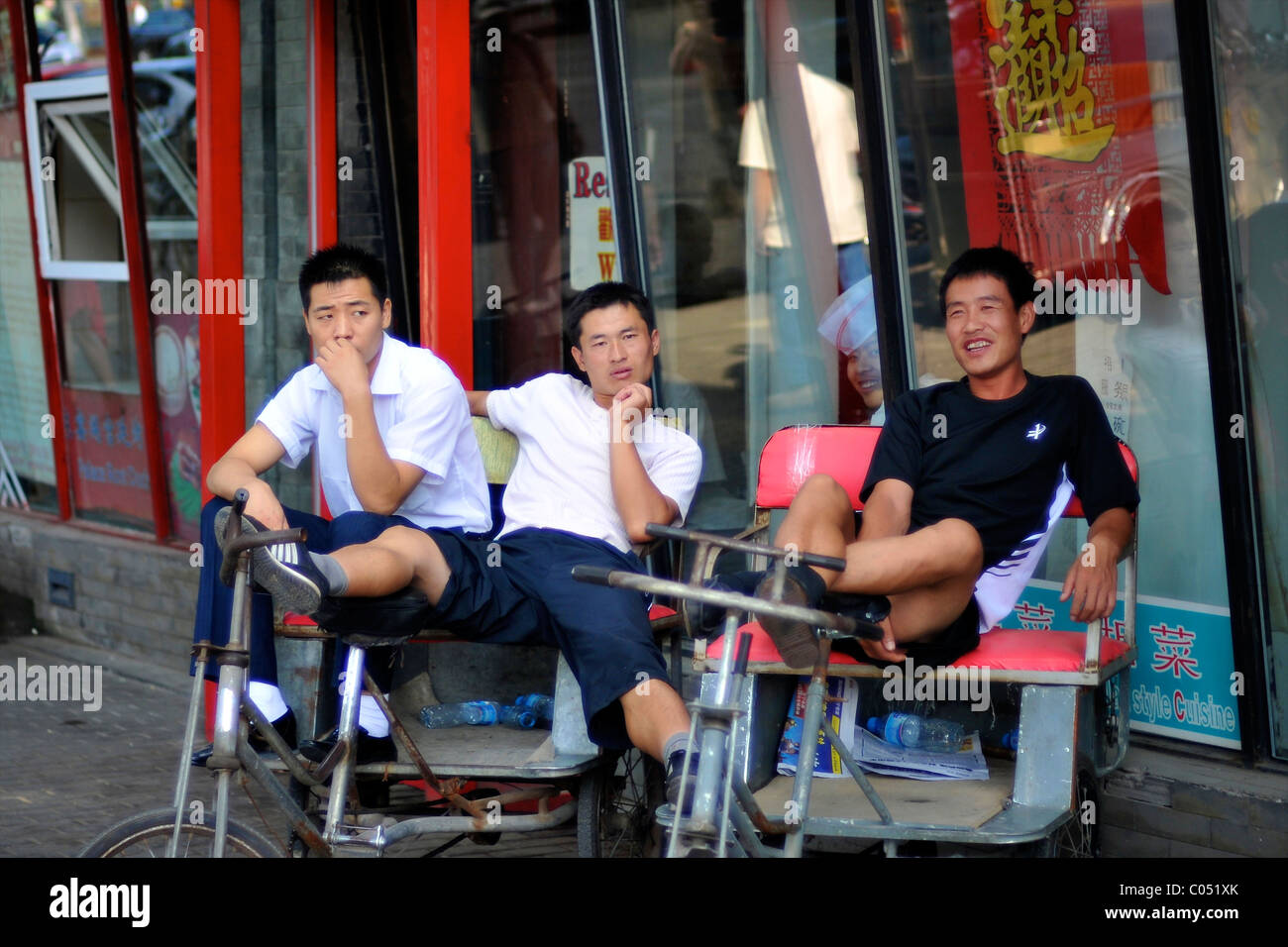 Rikscha-Radfahrer ruhen zwischen Jobs in Peking Stockfoto