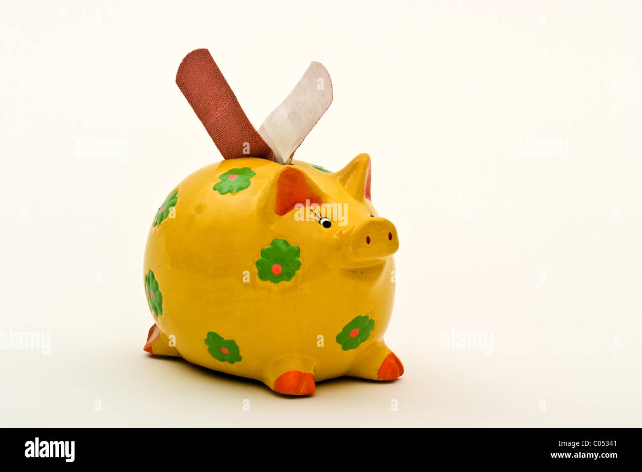 Sparschwein mit zwei Bandaids in die Münzschlitze Stockfoto