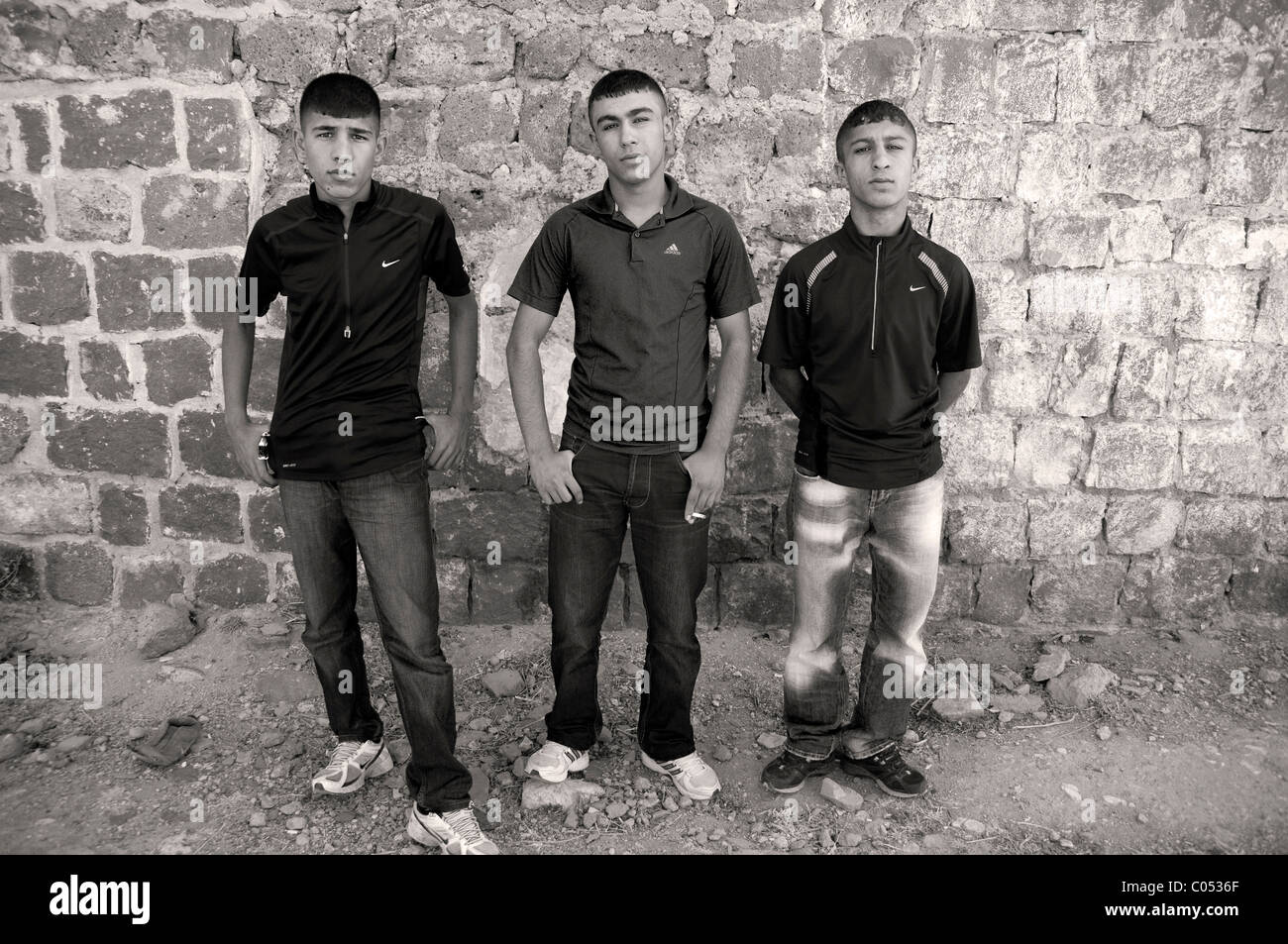 Drei kurdische Jugendliche stehen an den alten Mauern der Stadt Diyarbakir, in der östlichen Anatolien-Region im Südosten der Türkei. Stockfoto