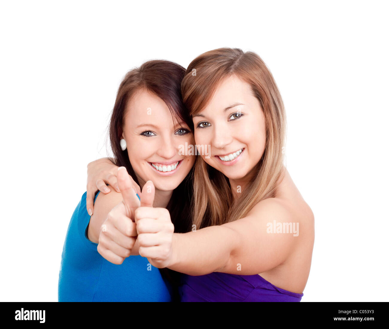 zwei junge Frauen auftauchend Daumen, lächelnd - isoliert auf weiß Stockfoto