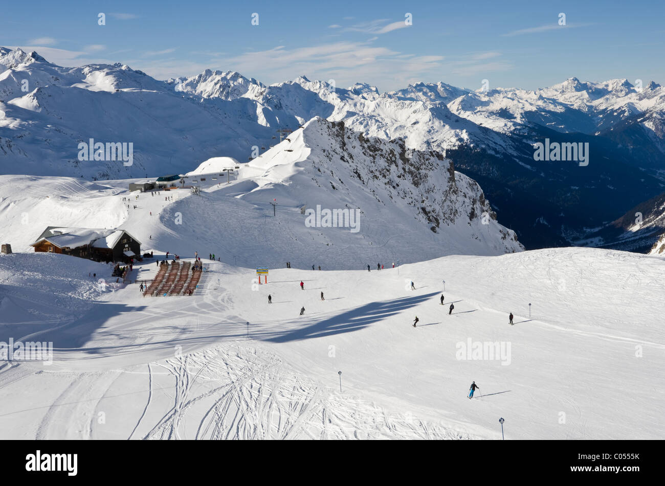 Skifahrer auf Skipisten über Ulmer Californias Bergrestaurant in den österreichischen Alpen. St. Anton am Arlberg, Tirol, Österreich, Europa. Stockfoto