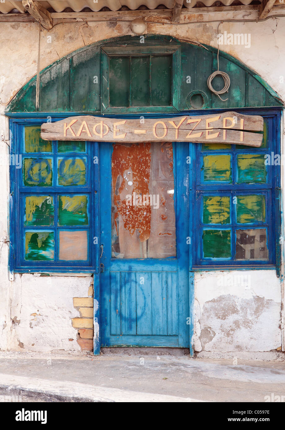 Eine heruntergekommene Cafébar in Panormo, Kreta, mit seinen griechischen Zeichen noch zu verkünden, sei es eine Cafe-Ouzeri Stockfoto