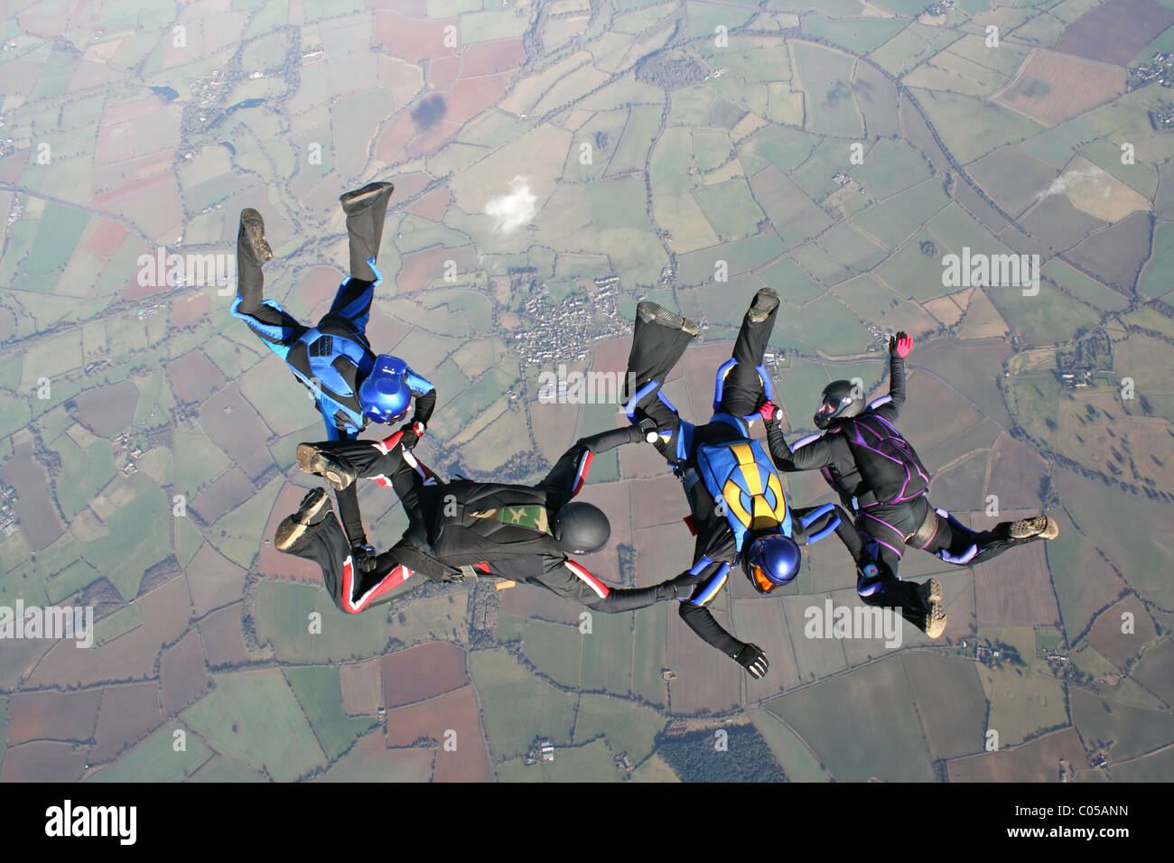 Vier Fallschirmspringer im freien Fall Formationen zu tun Stockfoto
