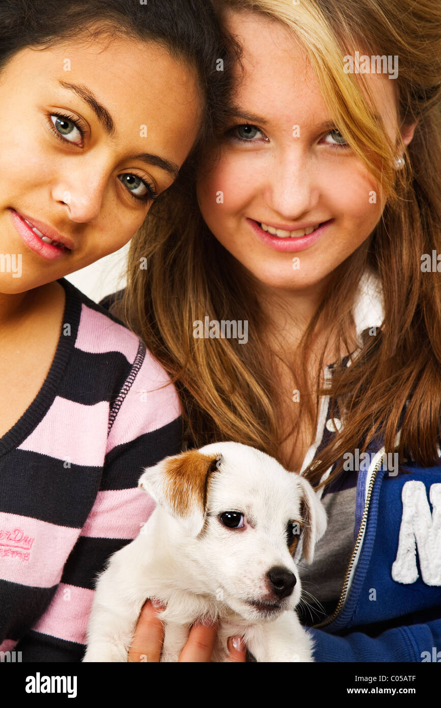 Zwei Mädchen im Teenageralter mit einem niedlichen kleinen Terrier Welpen. Stockfoto
