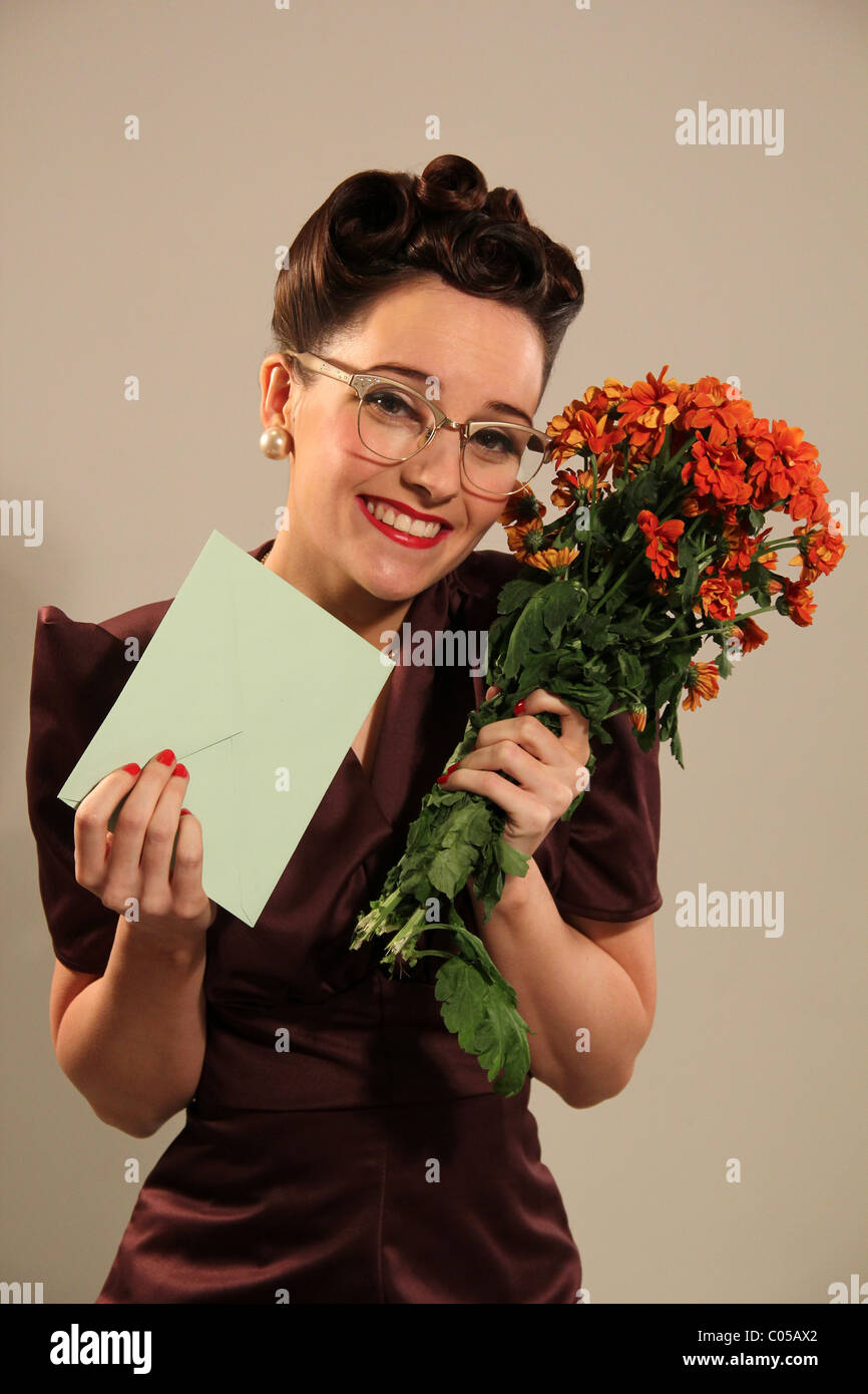 Altmodische Dame mit einer Karte und einem Blumenstrauß Stockfoto
