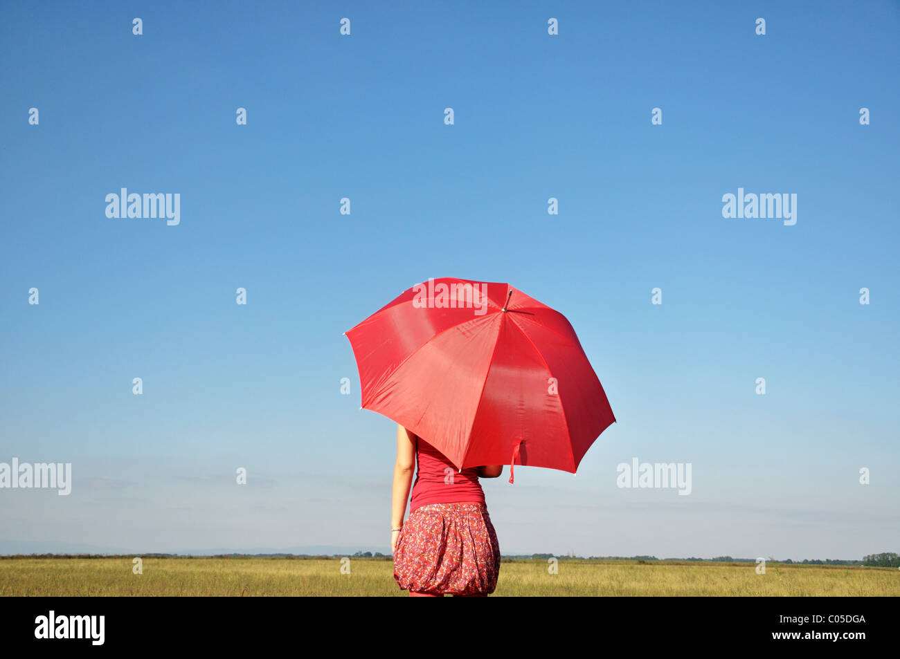 Junge Frau halten rote Regenschirm Stockfoto