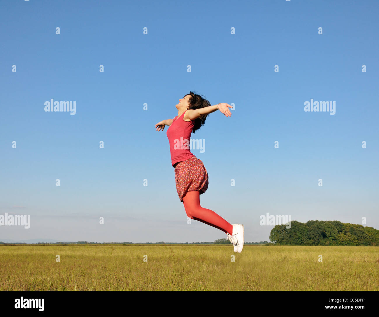 Junge Frau, die hoch in die Luft springen Stockfoto