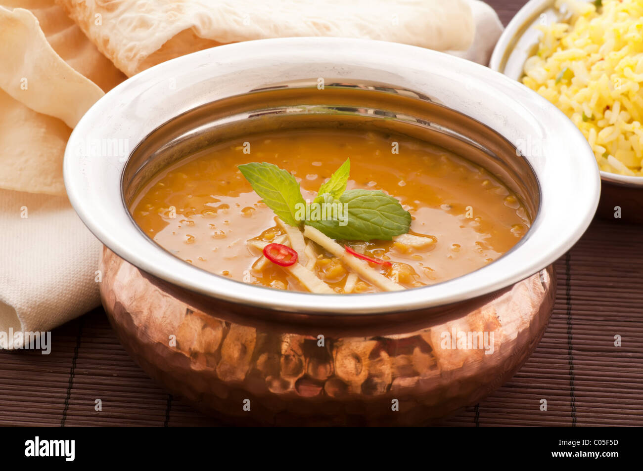 Linsensuppe mit Reis im Hintergrund in einem Messing Stockfoto