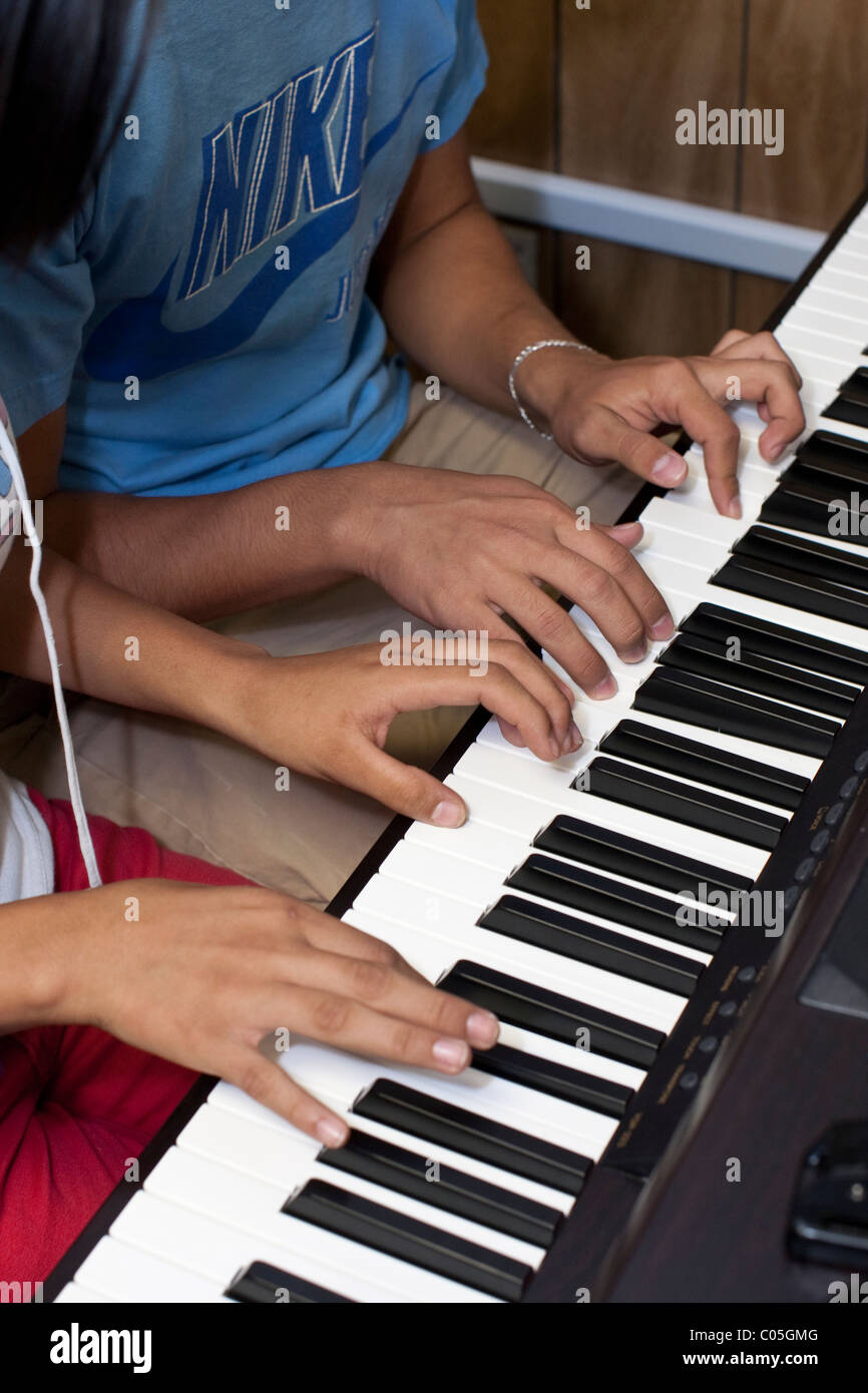 Hispanische High-School-jungen und Mädchen spielen im Musikunterricht Klavier an Mission Early College High School in El Paso TX Stockfoto