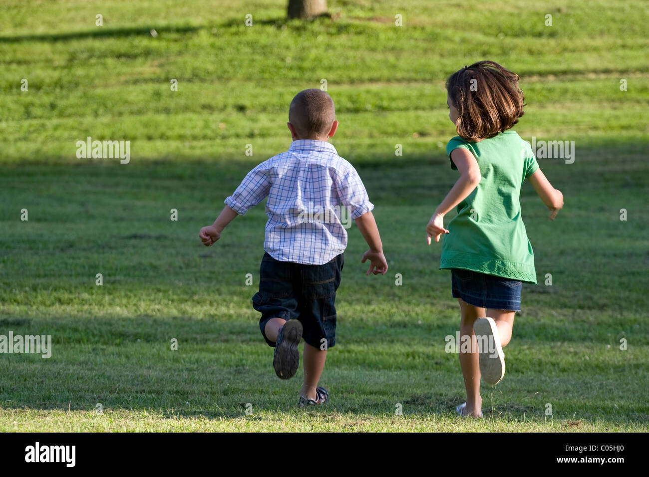 Einen kleinen Jungen und Mädchen laufen durch die Wiese ohne Sorge in der Welt. Stockfoto