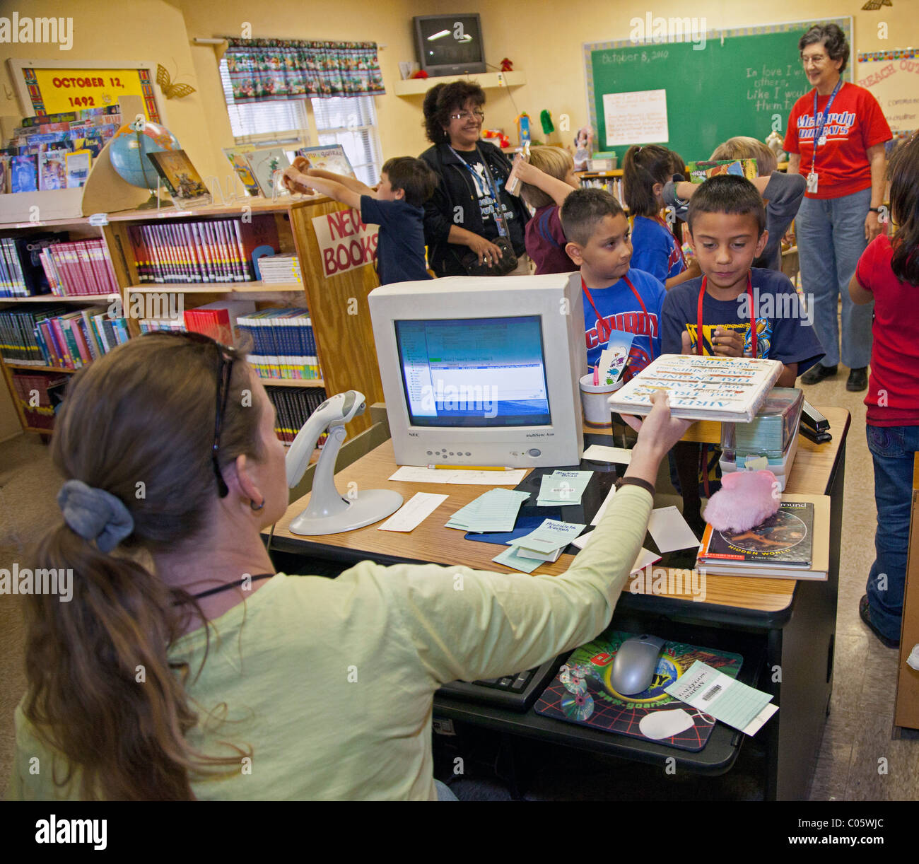 Kinder ausleihen von Büchern in der Schulbibliothek Stockfoto