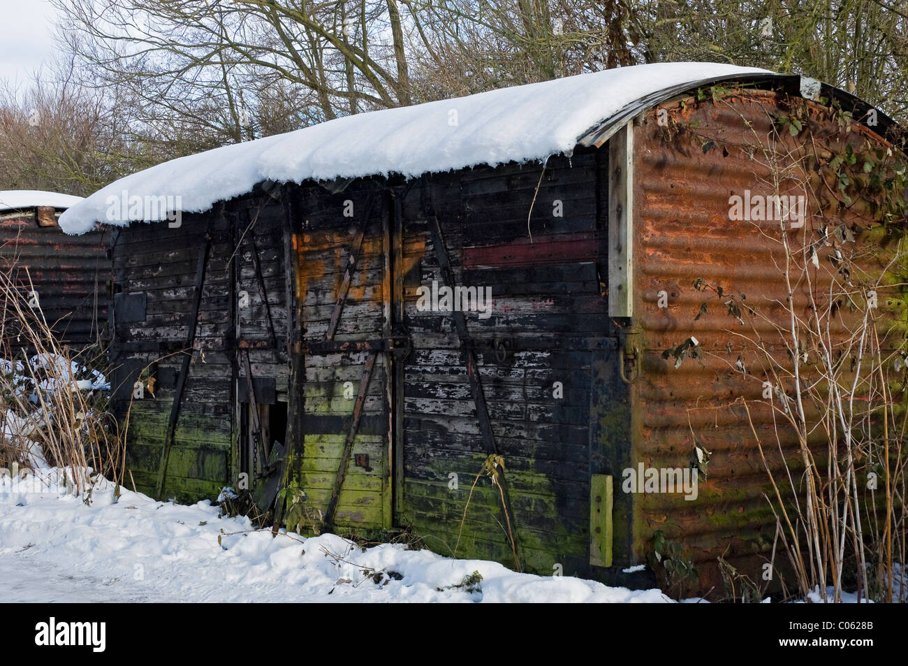 Schneebedeckter alter verlassener Güterwaggon auf einem Feld im Winter North Yorkshire England Vereinigtes Königreich GB Großbritannien Stockfoto