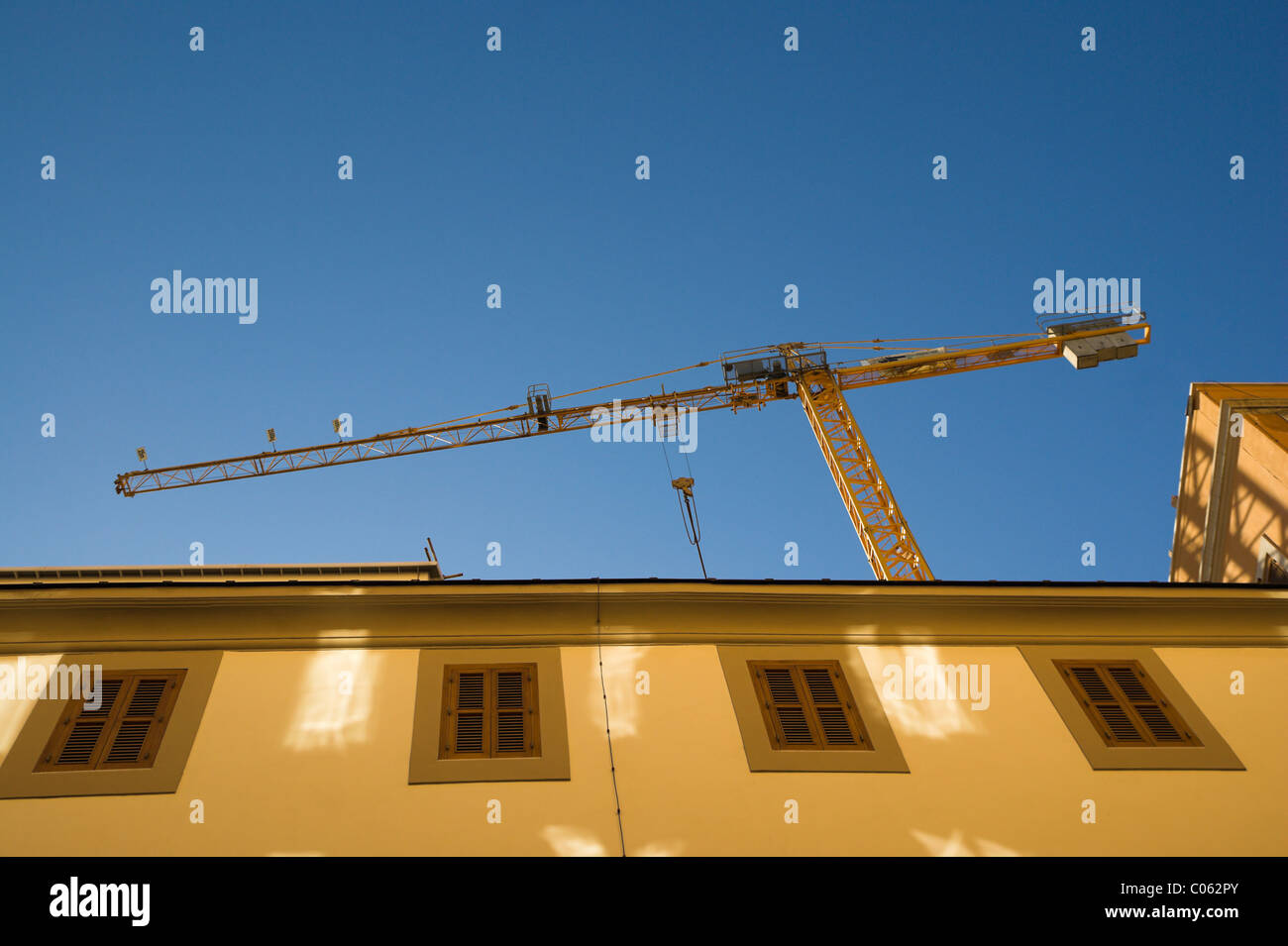Baukran über Gebäude, gegen blauen Himmel Stockfoto