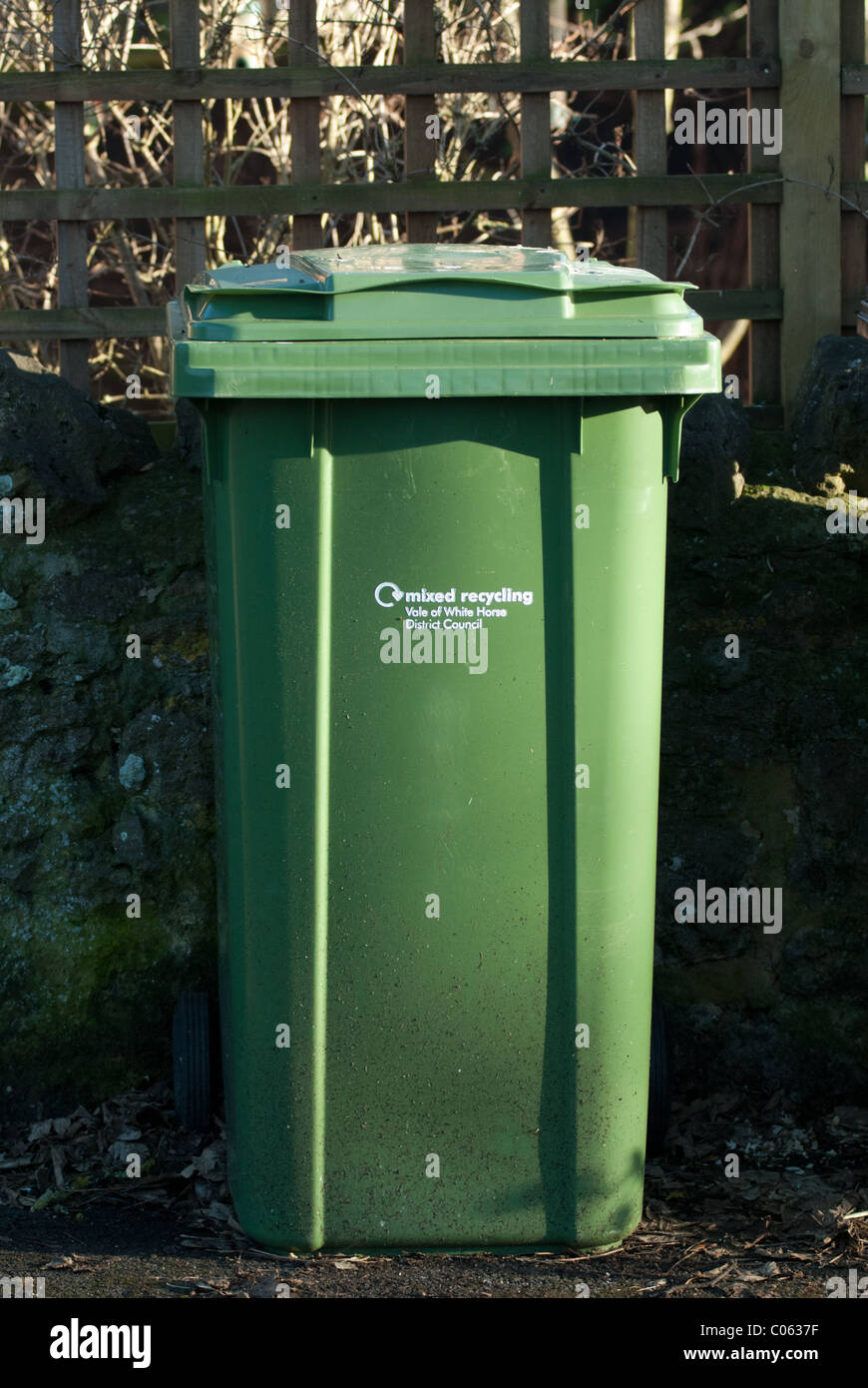 Ein grüner Kunststoff Wheelie bin, wartet auf einen vierzehntägigen Rat recycling Sammlung in einem UK-Land-Dorf. Stockfoto