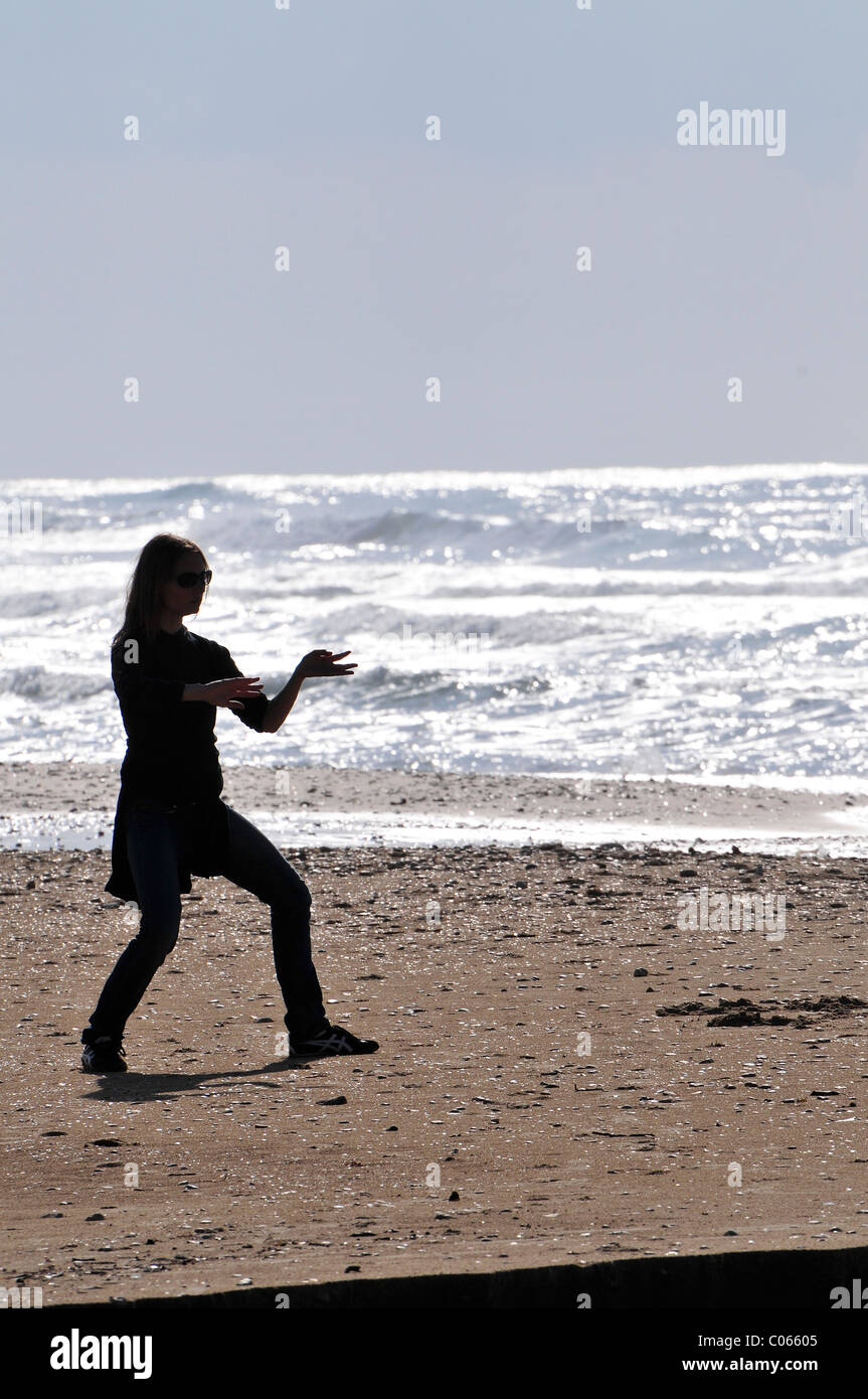 Silhouette einer Frau Tai Chi am Strand zu tun Stockfoto