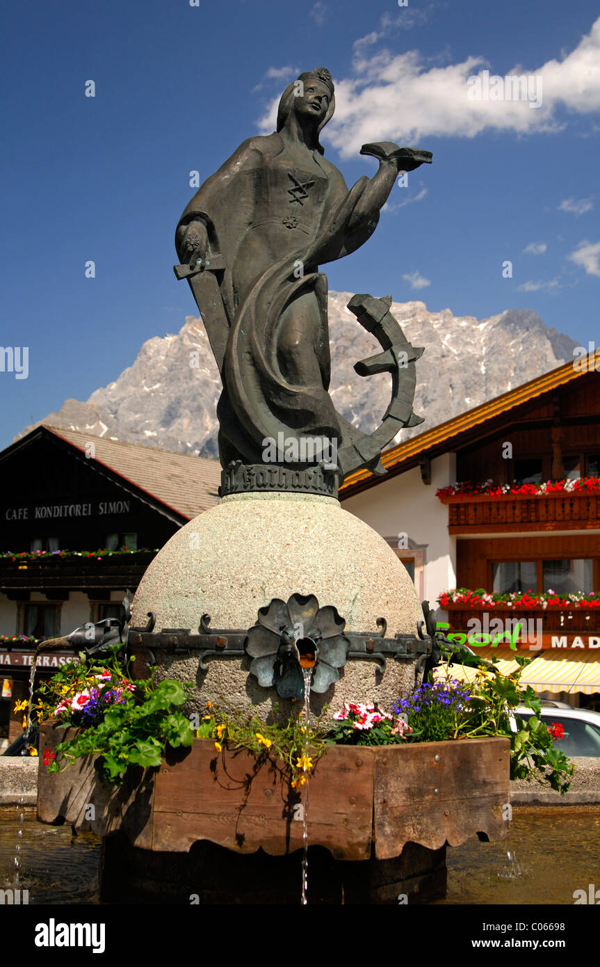 Dorfbrunnen mit einer Statue der Heiligen Katharina vor der Zugspitze massiv, Lermoos, Tirol, Austria, Europe Stockfoto