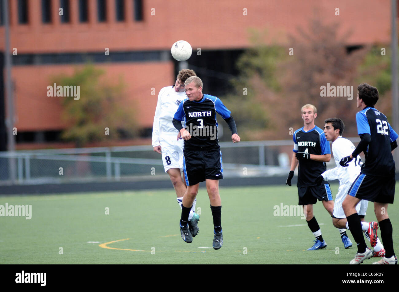 Spieler verwenden Header in einem Versuch, den Besitz der Kugel während einer High School Fußball Match zu gewinnen. USA. Stockfoto