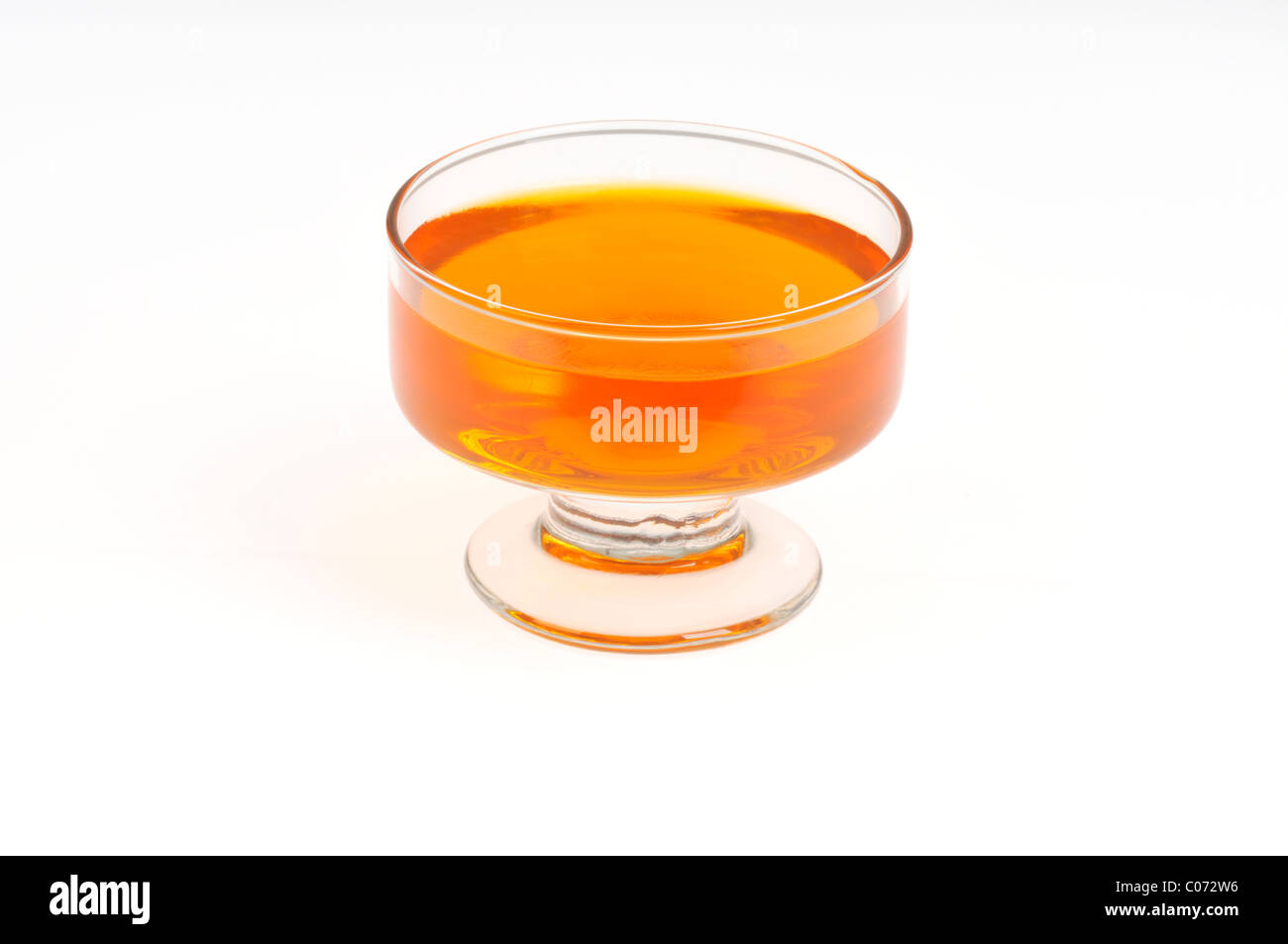 Portion des orange Jell-o Gelatin in Glas Servierplatte auf weißem Hintergrund, isoliert. Stockfoto