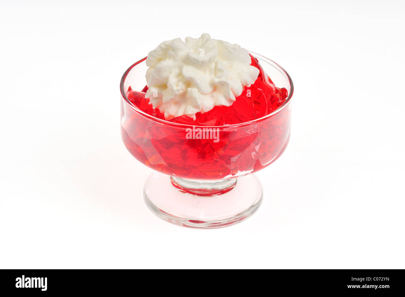 Erdbeere Jell-o mit gepeitschter Creme Belag in Glas Servierplatte auf weißem Hintergrund, isoliert. Stockfoto