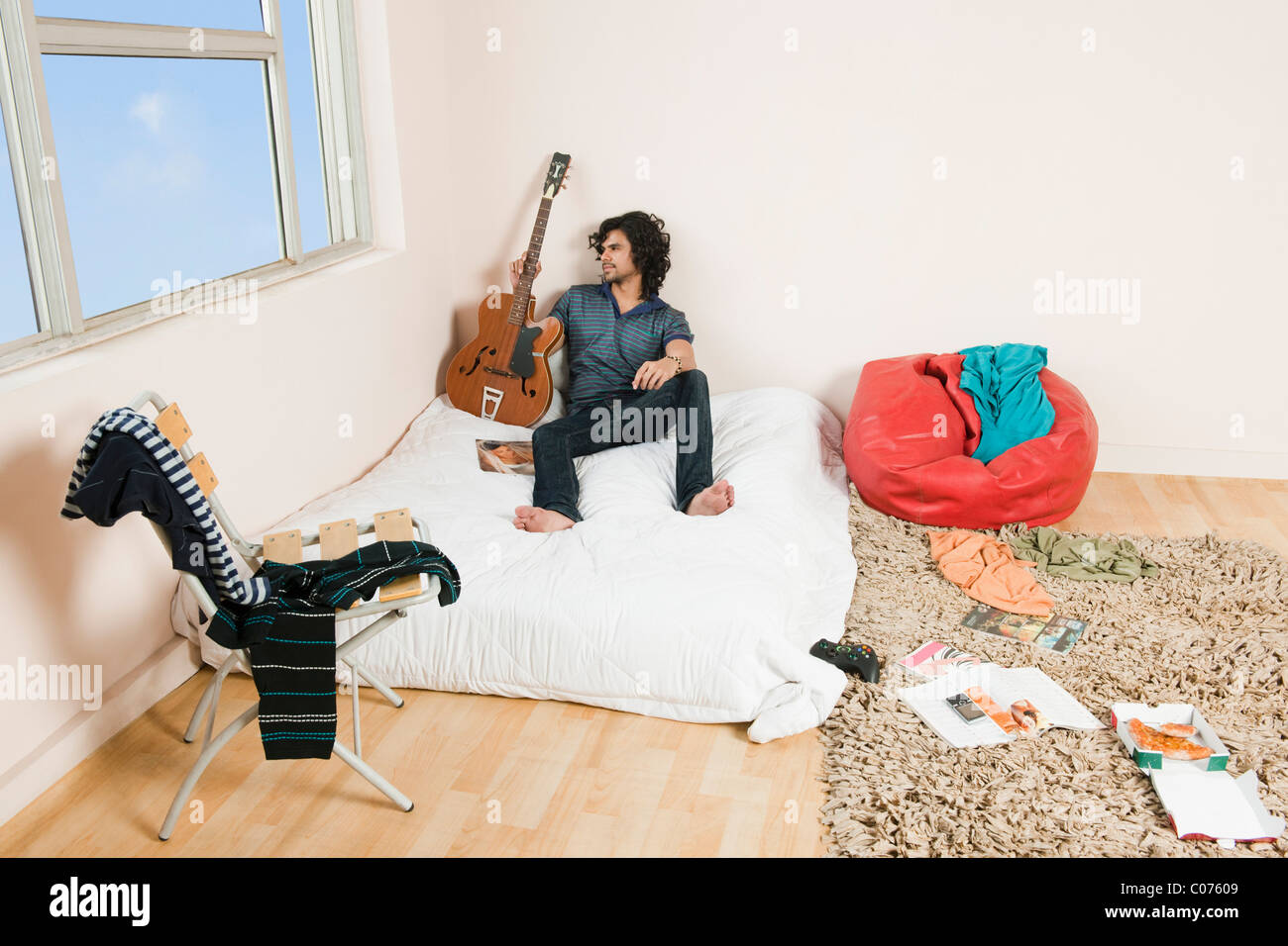 Vogelperspektive Blick auf ein Mann hält eine Gitarre im Schlafzimmer Stockfoto