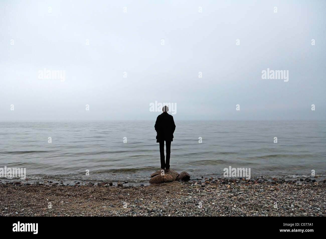 Junger Mann stehend bei schlechtem Wetter auf der Ostsee, Gross Schwansee, Mecklenburg-Western Pomerania, Deutschland, Europa Stockfoto