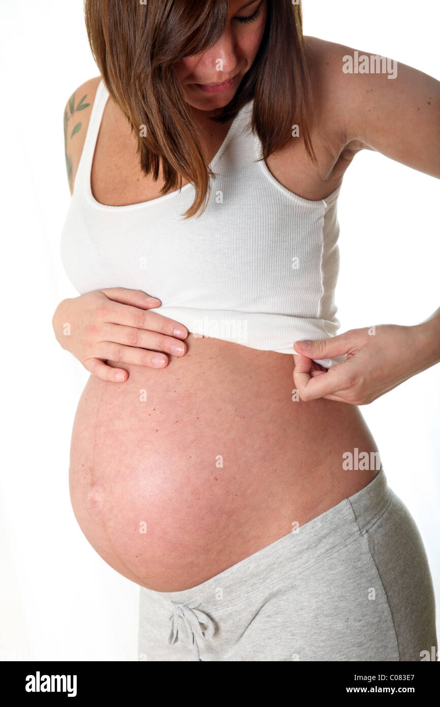 Schwangere Frau im casual-Look hält ihren Bauch Stockfoto