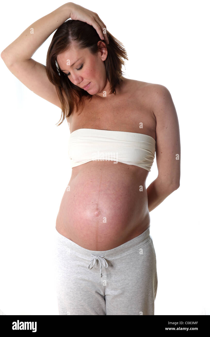 junge Frau mit Schwangerschaft-Bauch-weißer Hintergrund Blick auf ihren Bauch Stockfoto