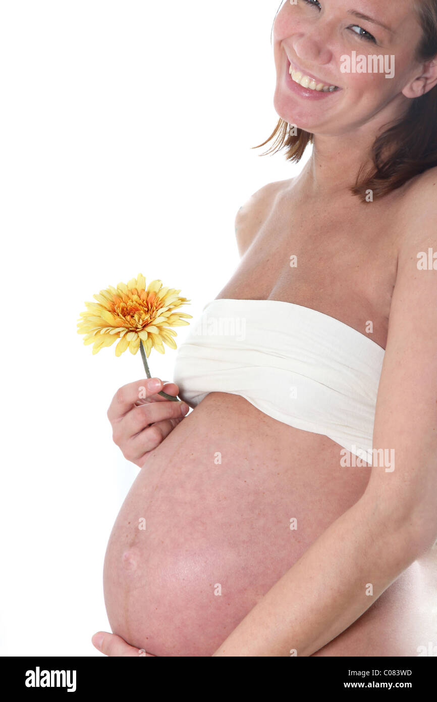 Glücklich, schwangere Frau von der Seite geschossen mit Blume in der hand Stockfoto