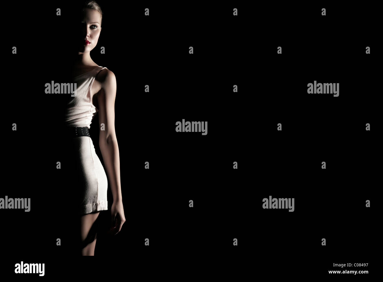 Junge Frau in einem weißen Kleid in Licht und Schatten Stockfoto